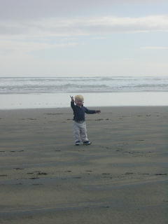 Niklas aan het dansen op het (zwarte) strand van Piha