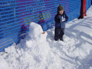 Niklas naast z'n 'snow-man' met een echte wortel neus